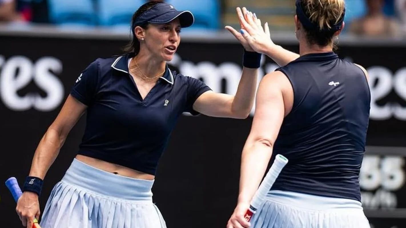 Luisa Stefani e Gabriela Dabrowski comemoram ponto com as mãos levantadas durante partida de duplas