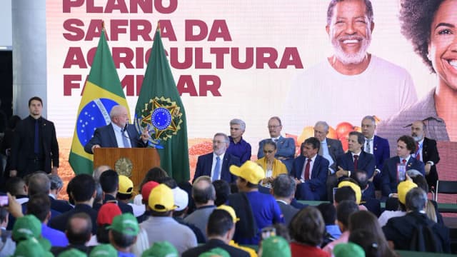 Lula discursa em evento oficial, com bandeiras do Brasil ao fundo