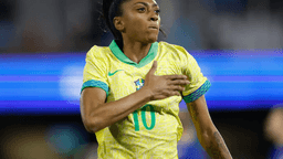 Kerolin comemora com a mão no peito vestindo a camisa amarela da seleção brasileira
