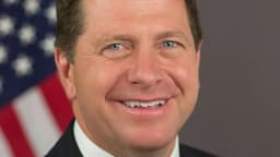 Retrato oficial de Jay Clayton, com a bandeira dos Estados Unidos ao fundo