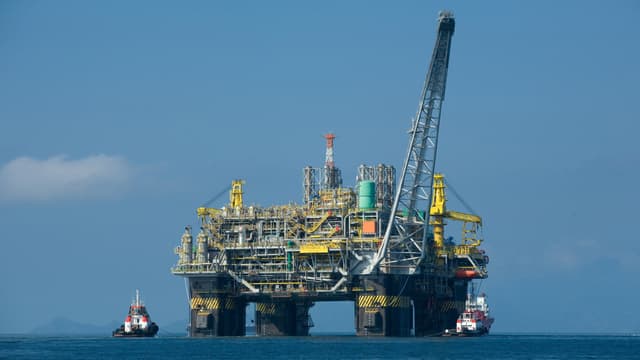 Plataforma de petróleo da Petrobras no mar, com rebocadores ao lado