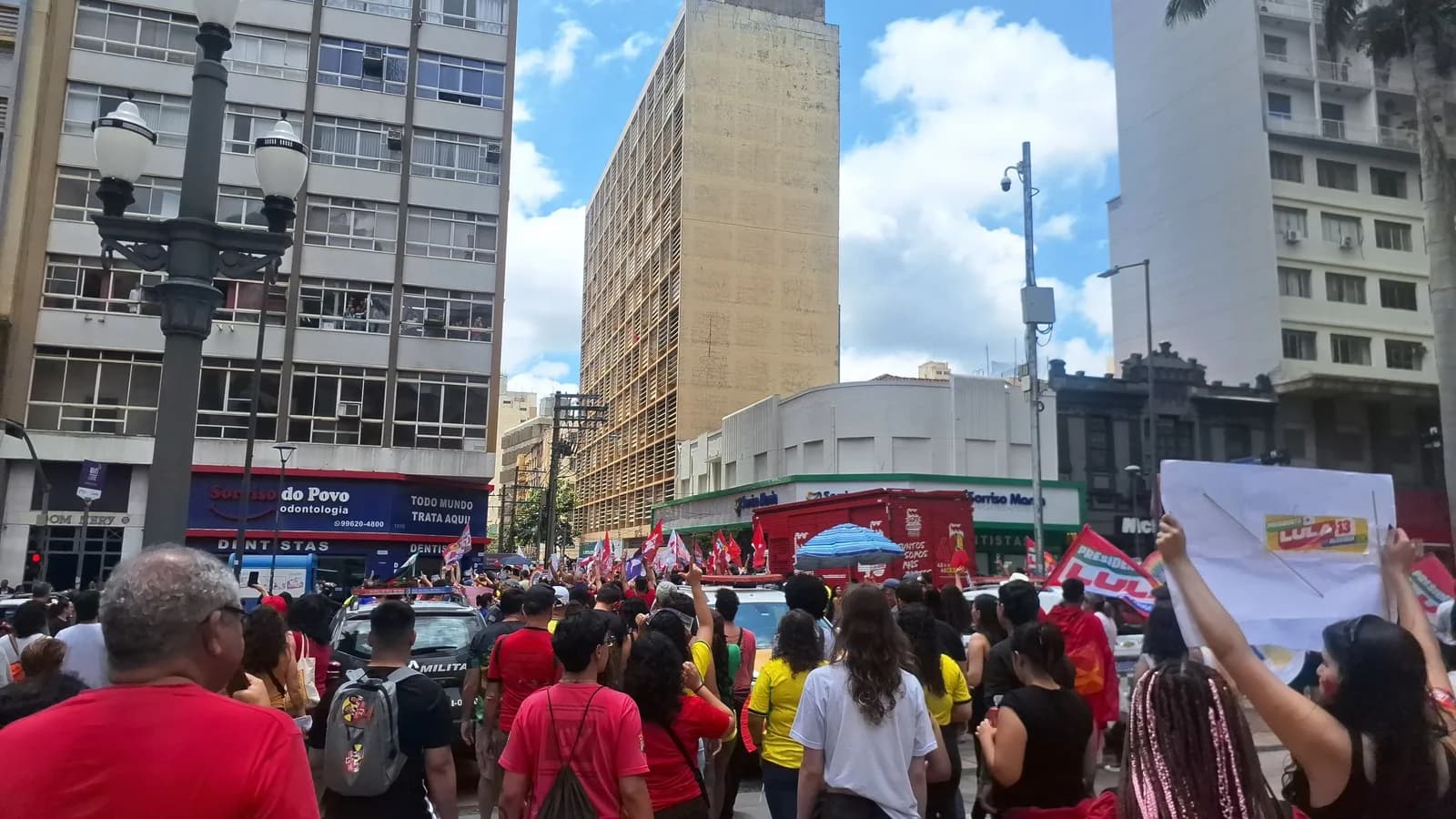Multidão em ato de campanha pró-Lula com bandeiras do Brasil