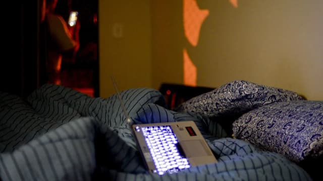 Cama com travesseiros em quarto escuro, campanha sobre sono saudável