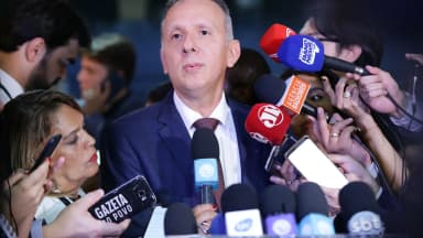 Deputado Aguinaldo Ribeiro, relator do PL 2338, fala à imprensa cercado de microfones (foto de arquivo)