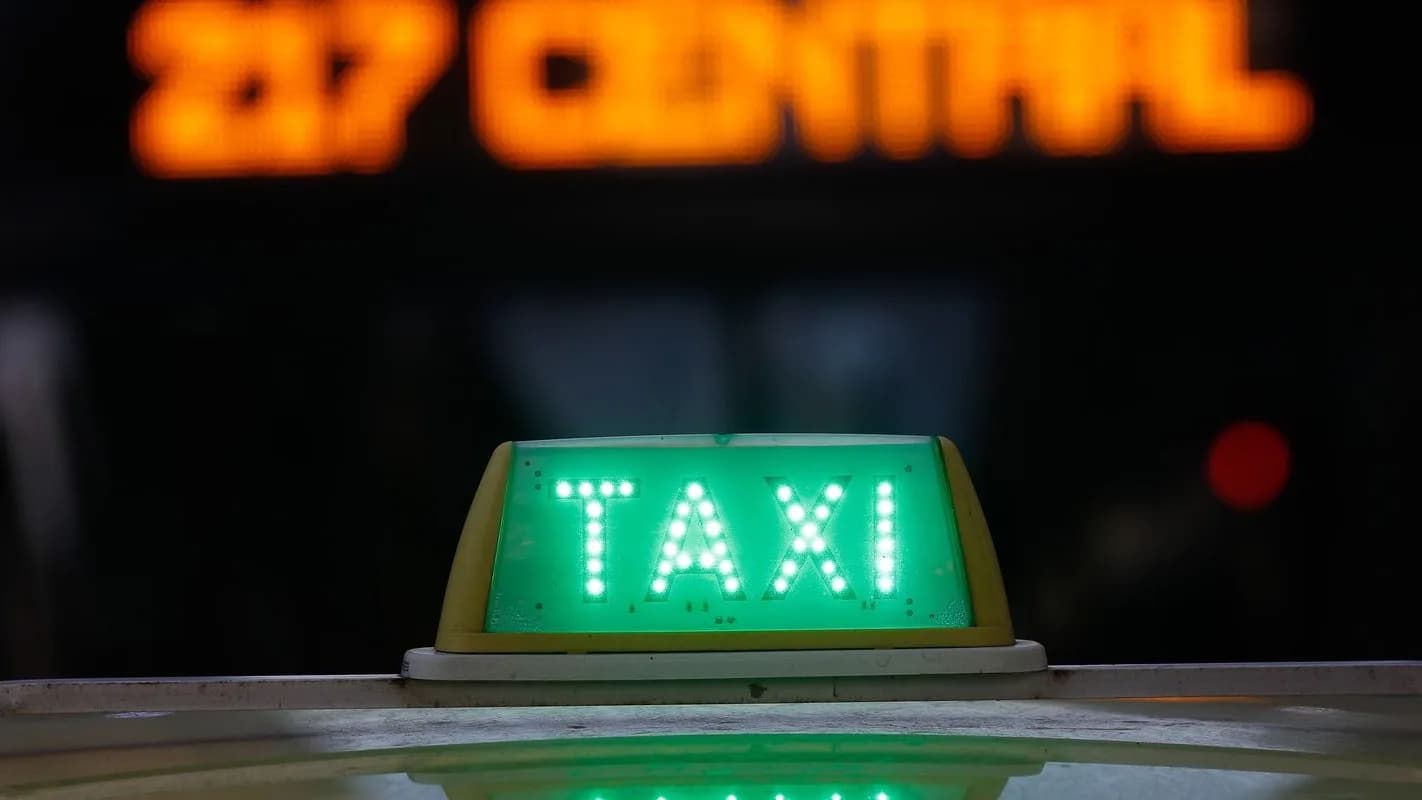 Luminoso verde de táxi aceso à noite sobre o teto de um veículo, foto de arquivo sobre crédito para taxistas