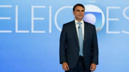 Flávio Bolsonaro em estúdio de TV com letreiro Eleições ao fundo