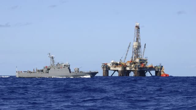 Navio-patrulha da Marinha do Brasil navega perto de plataforma de petróleo em alto-mar