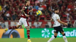 Jogador do Corinthians disputa bola com jogador do Flamengo em campo