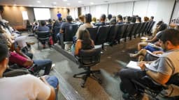 Candidatos sentados em auditório durante aula preparatória para concurso público, foto de arquivo