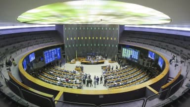 Plenário da Câmara dos Deputados durante sessão, com parlamentares e telões ao fundo