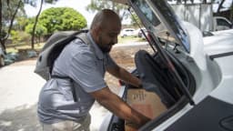 Trabalhador organiza urnas eletrônicas no porta-malas de um carro para distribuição às seções eleitorais