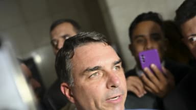 Senador Flávio Bolsonaro fala à imprensa cercado de microfones e repórteres no Senado