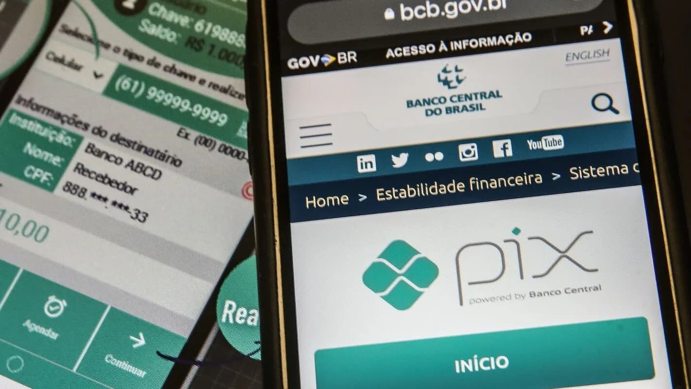 Celular mostra a página do Pix no site do Banco Central ao lado de outro celular com uma transferência Pix em andamento