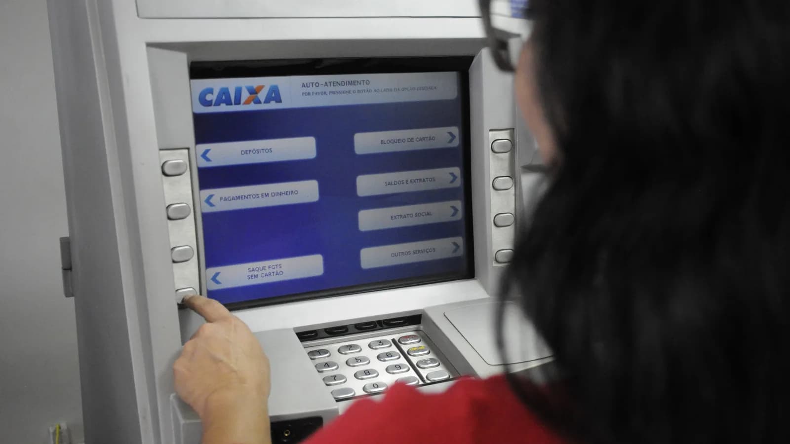 Pessoa usa terminal de autoatendimento da Caixa Econômica Federal