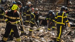 Bombeiros do Serviço Estadual de Emergência da Ucrânia trabalham em meio a escombros após ataque russo em Kharkiv