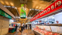 Comerciantes trabalham em banca de mercado público no Brasil, imagem ilustrativa