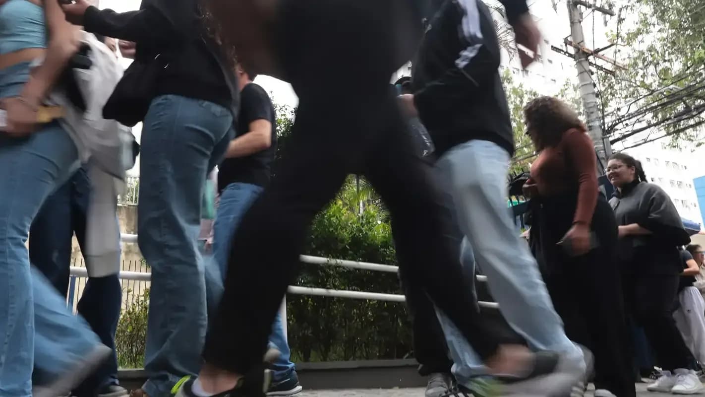 Candidatos caminham em fila para entrar em local de prova de concurso