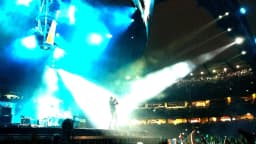 Bono, vocalista do U2, durante show com plateia ao fundo