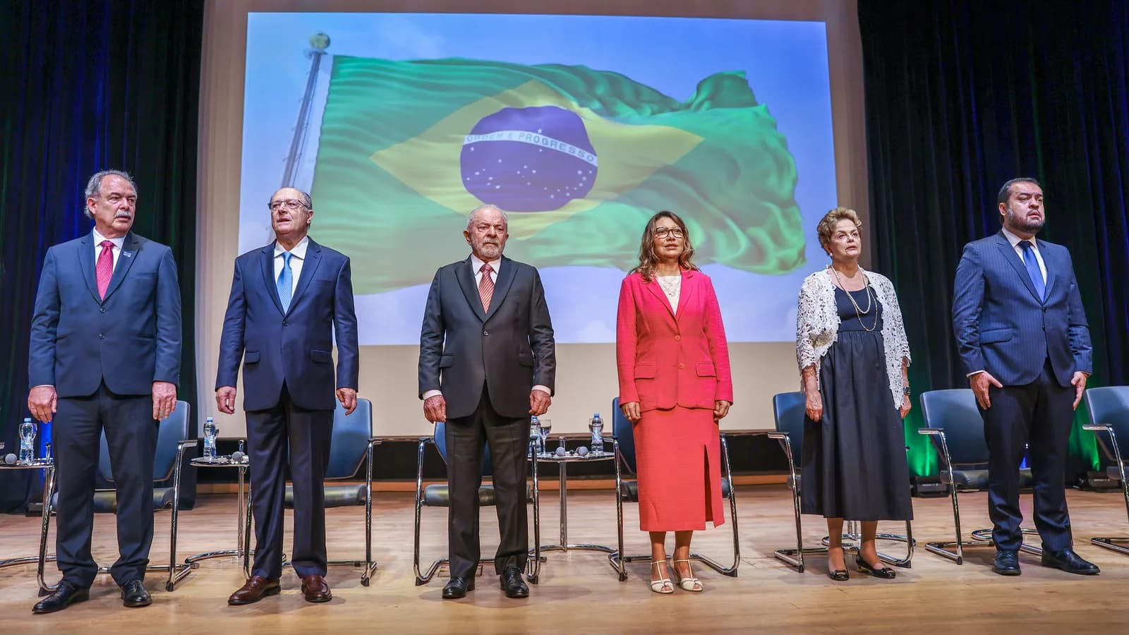 Aloizio Mercadante ao lado de Lula, Geraldo Alckmin, Dilma Rousseff e outras autoridades em cerimônia com bandeira do Brasil ao fundo