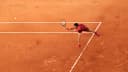 Novak Djokovic se estica para alcançar a bola durante partida de tênis em quadra de saibro