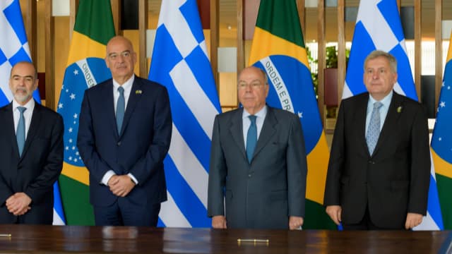 O chanceler Mauro Vieira em reunião diplomática com autoridades estrangeiras, diante das bandeiras do Brasil e do país anfitrião