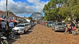 Rua de pedras do centro histórico de Tiradentes (MG) com turistas, charretes e cafés (foto de arquivo)