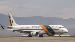 Jato da Embraer pintado com as cores da bandeira do Brasil, em pista de pouso