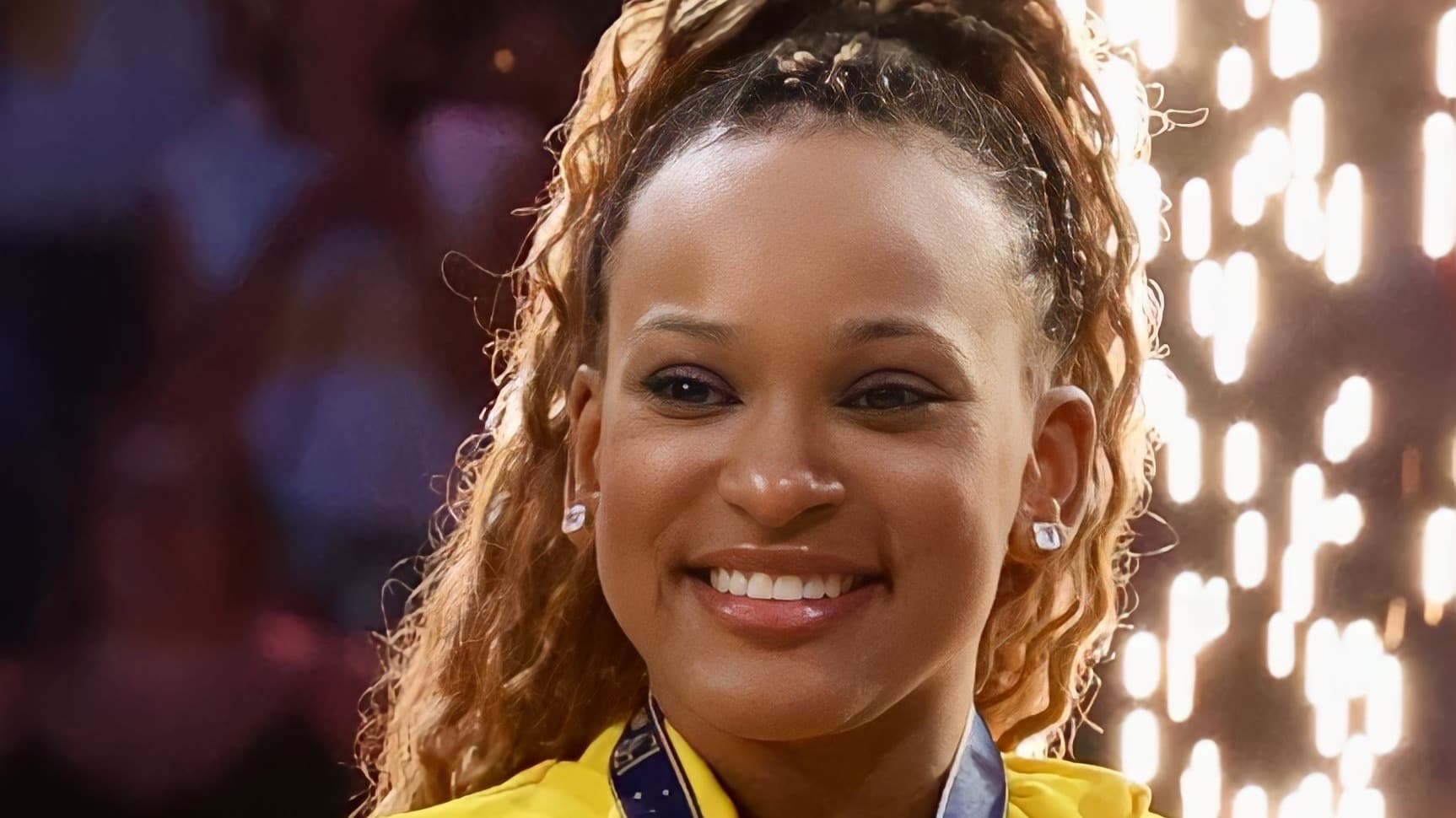 Rebeca Andrade sorri com medalha e uniforme amarelo da seleção brasileira de ginástica