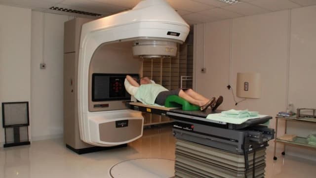 Paciente em sessão de radioterapia em hospital, tratamento associado ao câncer