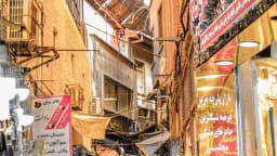 Pessoas caminham e fazem compras em corredor do bazar histórico de Teerã, no Irã