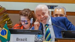 Lula usa fone de tradução em mesa internacional com a placa do Brasil