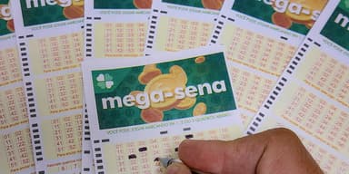 Mão marca números em volantes da Mega-Sena com caneta