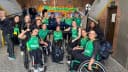 Jogadoras da seleção brasileira feminina de basquete em cadeira de rodas comemoram reunidas com bandeira do Brasil