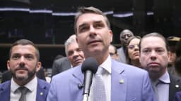 Flávio Bolsonaro fala ao microfone cercado de parlamentares no Congresso, foto de arquivo