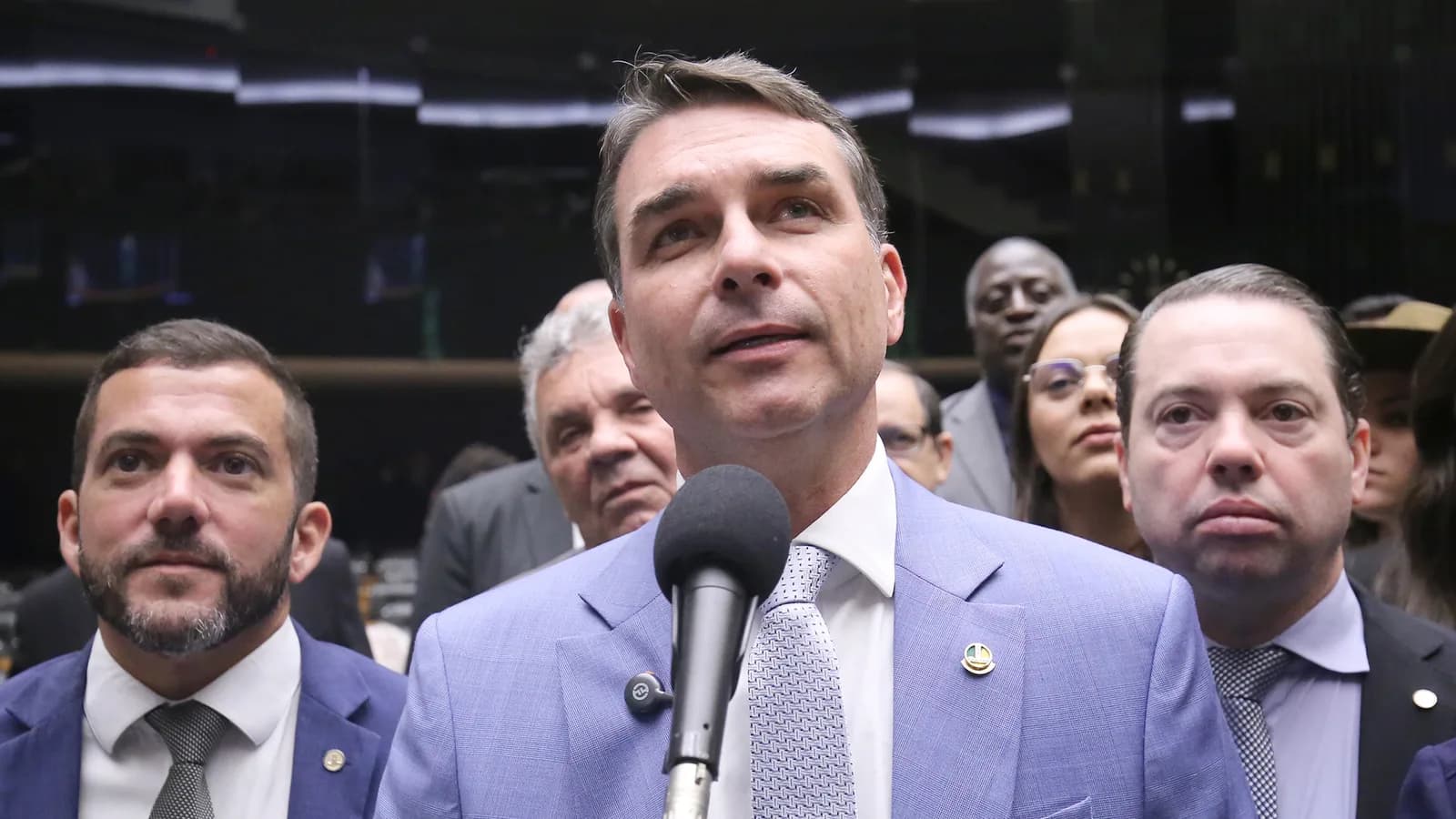 Flávio Bolsonaro fala ao microfone cercado de parlamentares no Congresso, foto de arquivo