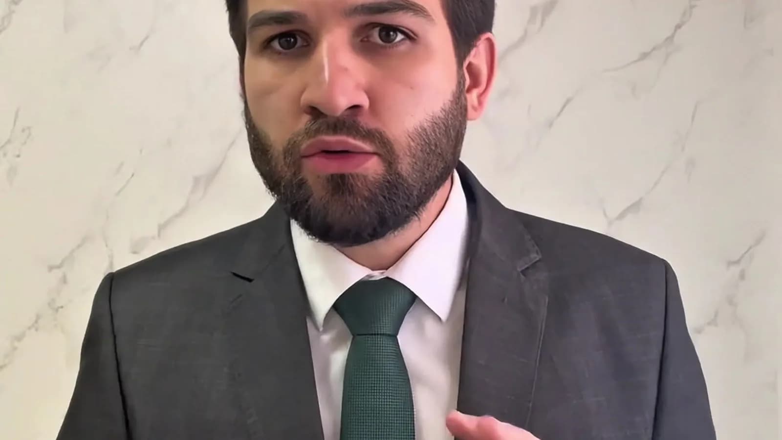 Advogado Dr. Pedro Gueggua, de terno cinza e gravata verde, gesticula com as duas mãos ao explicar o crime eleitoral de votar no lugar de outra pessoa