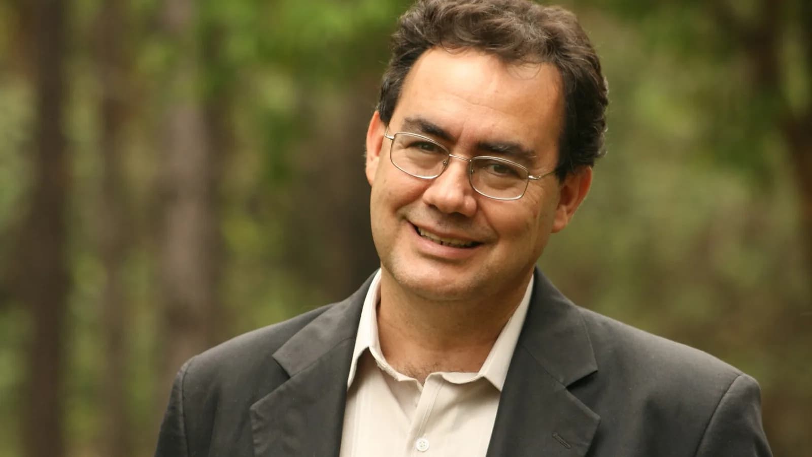 Retrato de Augusto Cury sorrindo, de óculos e blazer escuro, em imagem de arquivo