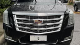 Cadillac Escalade preto estacionado, vista frontal com grade cromada