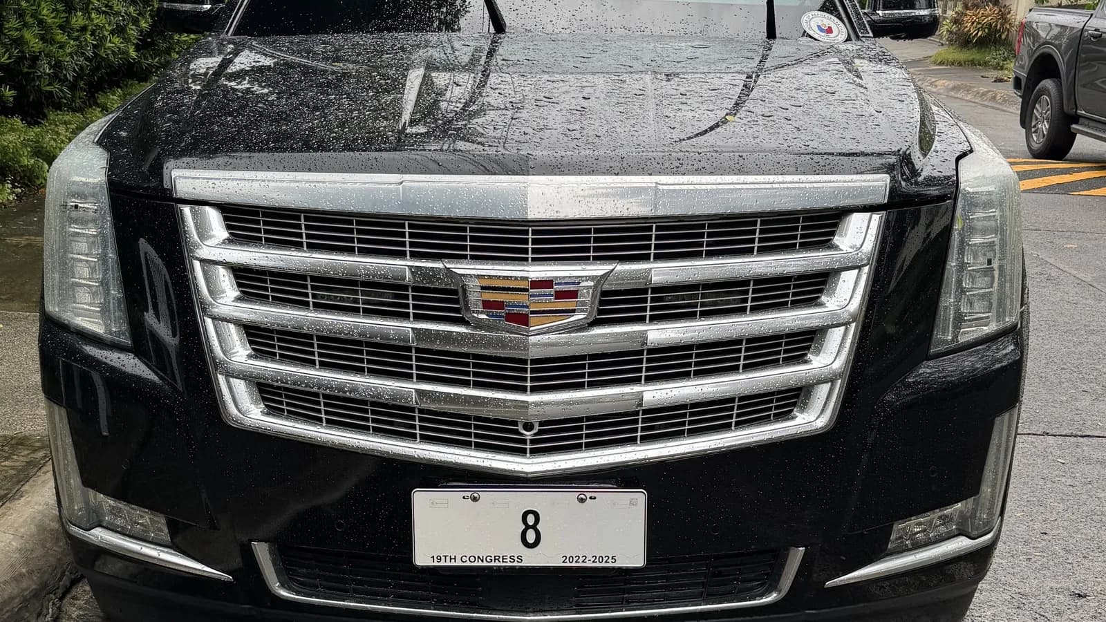 Cadillac Escalade preto estacionado, vista frontal com grade cromada