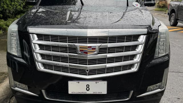 Cadillac Escalade preto estacionado, vista frontal com grade cromada