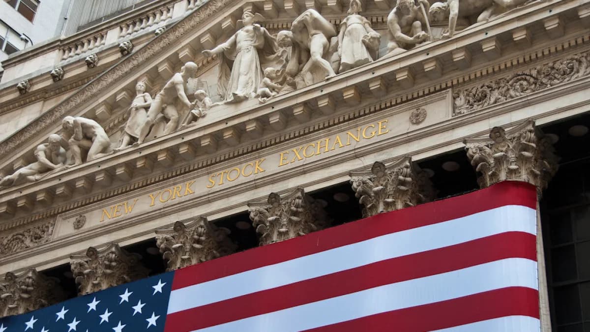 Fachada da Bolsa de Valores de Nova York (NYSE) com uma grande bandeira dos Estados Unidos