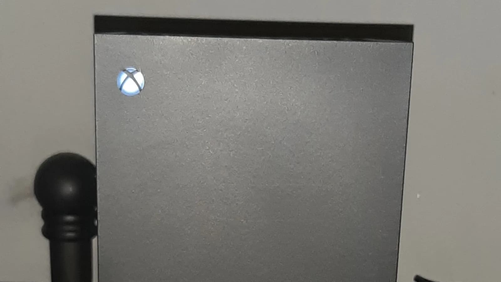 Console Xbox Series X com logo iluminado e controle em primeiro plano