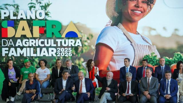 Produtora rural sorri em frente a banner do Plano Safra da Agricultura Familiar
