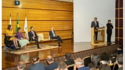 Plateia e mesa de autoridades em evento institucional da Anatel, com logotipo da agência no púlpito