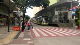 Corredor do sistema Move no centro de Belo Horizonte, com ônibus articulado parado em estação e pedestres na calçada. Imagem de arquivo do sistema Move, de contexto — não é do ataque de 2021