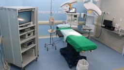 Sala de cirurgia com maca e aparelho de anestesia