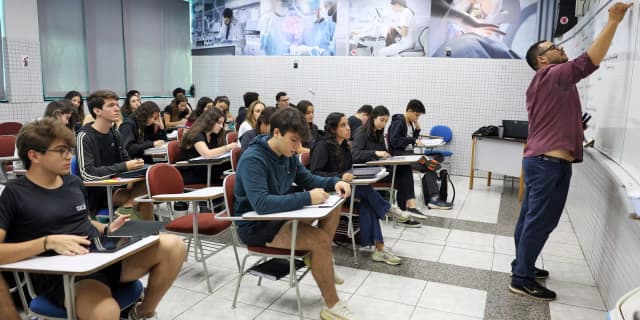 Sala de aula cheia de estudantes se preparando para prova, cena ilustrativa