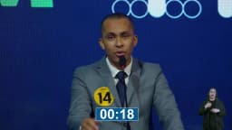 Ben Mendes, candidato ao governo de Minas Gerais com o número 14, fala ao microfone no púlpito do debate, em tom firme