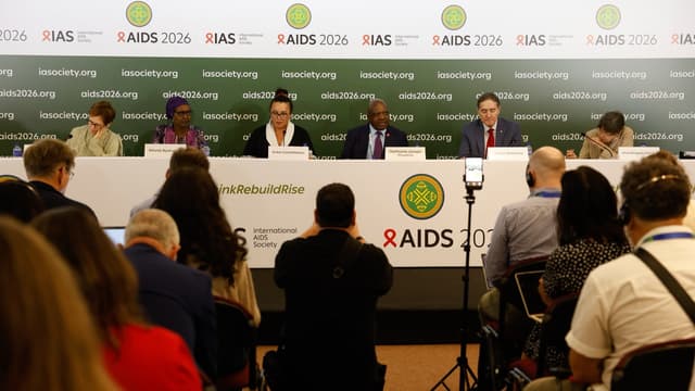 Painel de autoridades durante coletiva de imprensa de abertura da Conferência Internacional de Aids 2026, no Rio de Janeiro, com o banner oficial do evento ao fundo