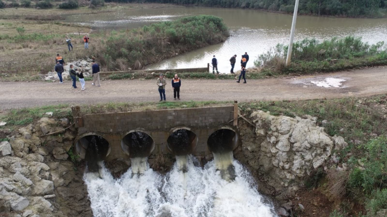 Vista aérea da barragem Santa Lúcia, com quatro galerias vertendo água, e equipes técnicas reunidas na estrada sobre a estrutura, entre Ilópolis e Putinga, no Rio Grande do Sul